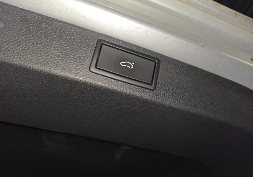 Bouton d'ouverture électrique du hayon dans le coffre du Skoda Karoq gris 2023.