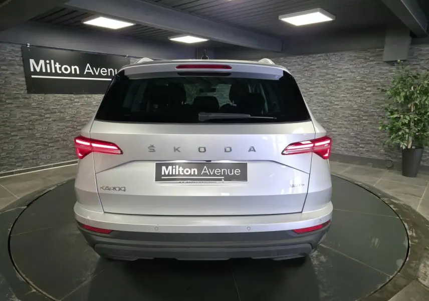 Vue arrière d'un Skoda Karoq gris 2023 avec feux LED allumés dans un showroom intérieur.