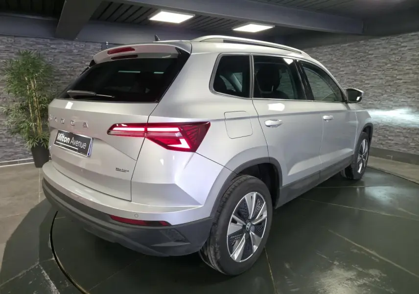 Vue 3/4 arrière droit du Skoda Karoq gris 2023 avec feux arrière LED et jantes alliage 17 pouces.