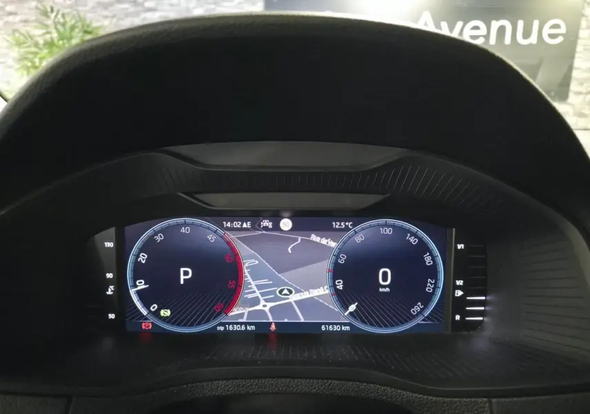 Vue du tableau de bord numérique du Skoda Karoq gris 2023, affichant la navigation et les compteurs digitaux.