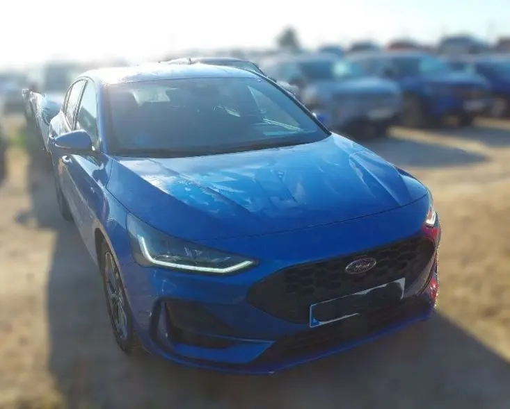 Ford Focus 1.0 EcoBoost MHEV 155CV bleu vue 3/4 avant avec calandre noire et feux LED allumés.