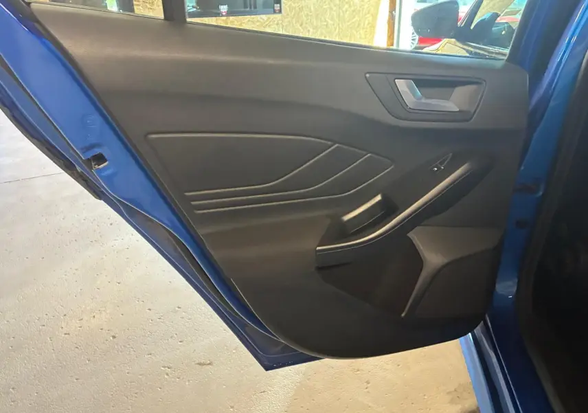 Vue intérieure de la porte arrière gauche bleu de la Ford Focus 2024, avec habillage noir et poignée intégrée.