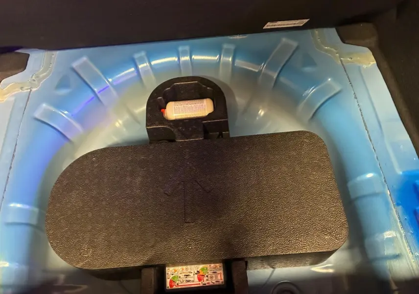Détail du coffre montrant la roue de secours et le compartiment bleu clair sous le plancher d’une Ford Focus 2024.