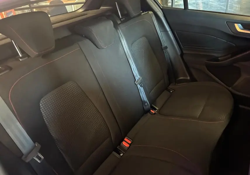 Vue intérieure côté droit des sièges arrière noirs en tissu avec surpiqûres rouges de la Ford Focus 2024.
