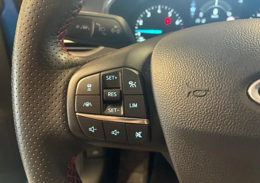Gros plan sur le volant perforé noir avec commandes de régulateur et limiteur de vitesse de la Ford Focus 2024.