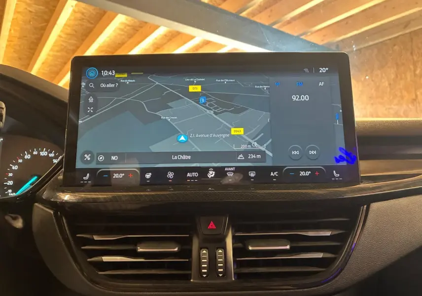 Écran tactile central affichant la navigation et la radio dans le tableau de bord noir d’une Ford Focus 2024.