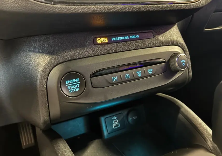 Détail du tableau de bord de la Ford Focus 2024, montrant le bouton start/stop et commandes climatisation en noir.