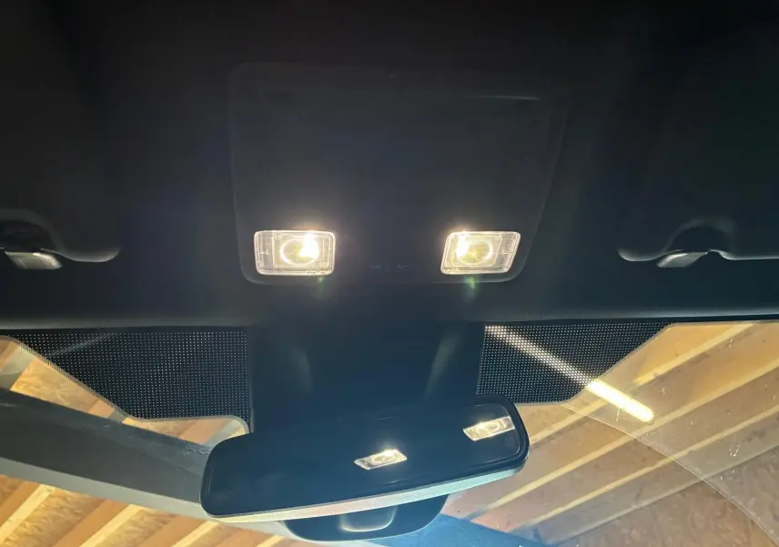 Vue intérieure centrée sur le rétroviseur et les plafonniers allumés d'une Ford Focus 2024.