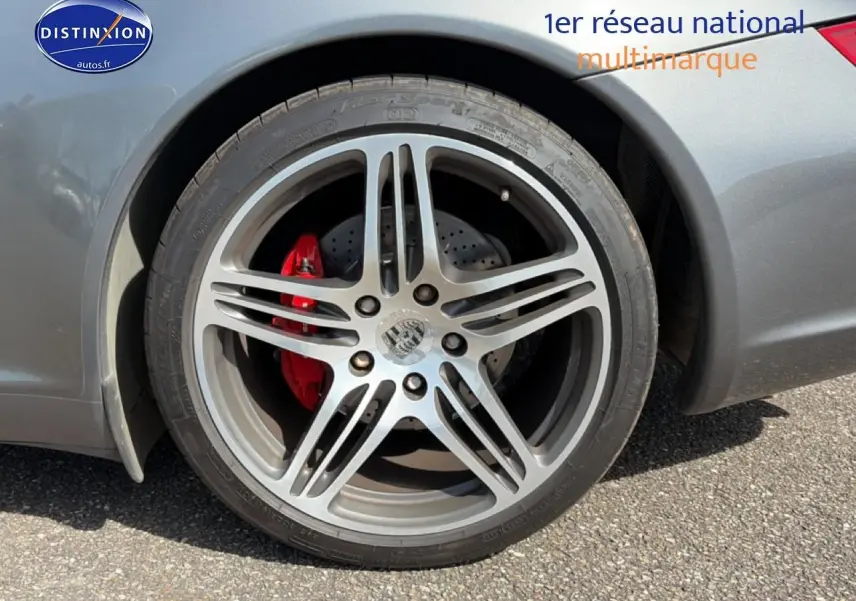 Gros plan sur la roue arrière droite grise d'une Porsche 911 (997) Carrera S avec étrier de frein rouge visible.
