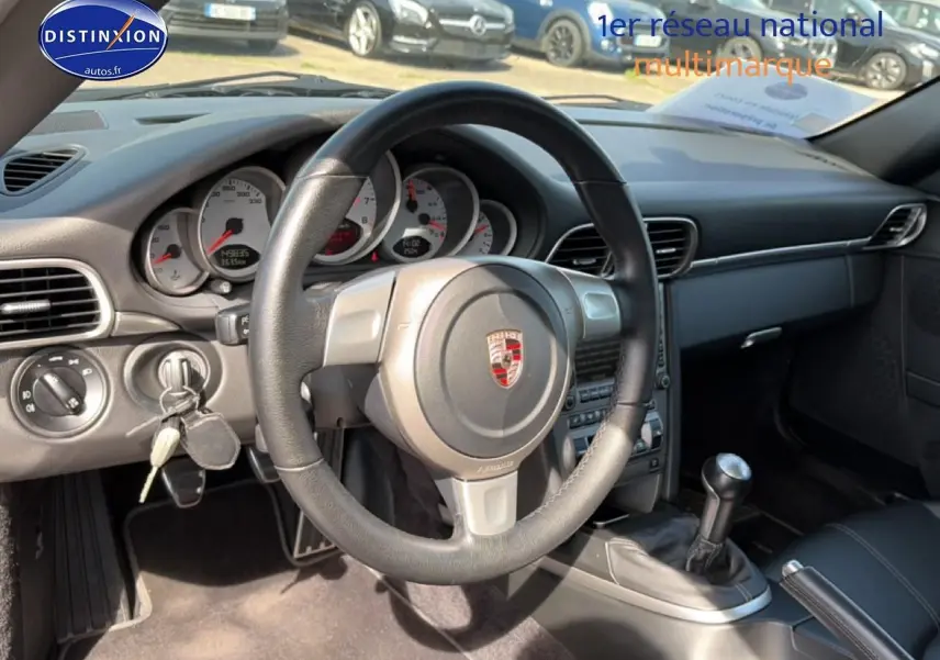 Vue intérieure de la Porsche 911 (997) Carrera S 2008, volant cuir, tableau de bord et levier de vitesse manuel visibles.