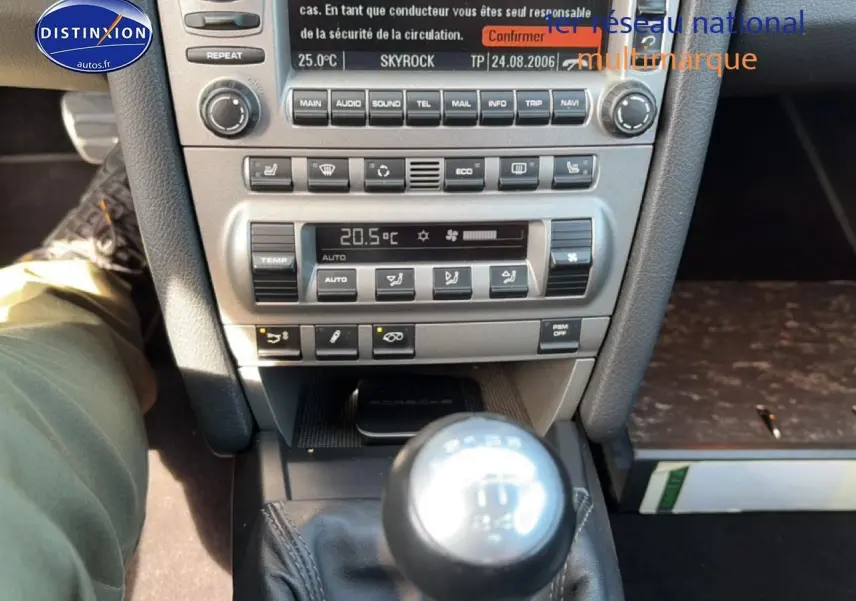 Vue rapprochée de la console centrale et levier de vitesses manuel d'une Porsche 911 (997) Carrera S gris, intérieur cuir.