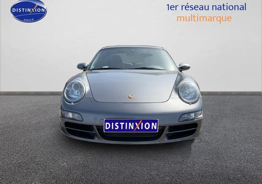 Vue frontale d'une Porsche 911 (997) Carrera S gris métallisé, avec phares ronds caractéristiques et calandre basse.