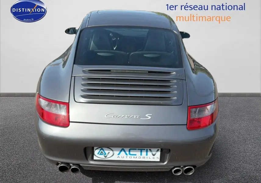 Vue arrière d'une Porsche 911 (997) Carrera S gris métallisé avec double sortie d'échappement et toit ouvrant électrique visible.
