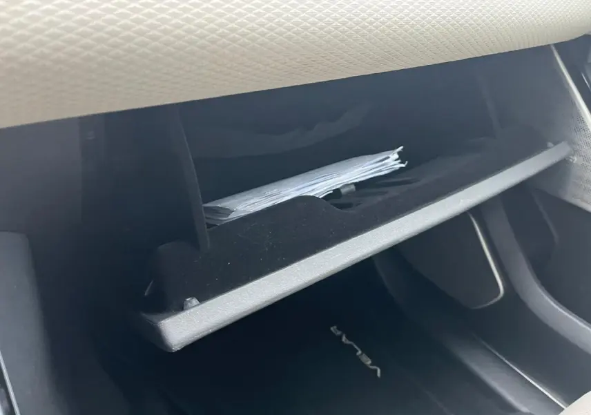 Gros plan sur la boîte à gants ouverte du Range Rover Velar 2017, montrant des documents à l'intérieur.