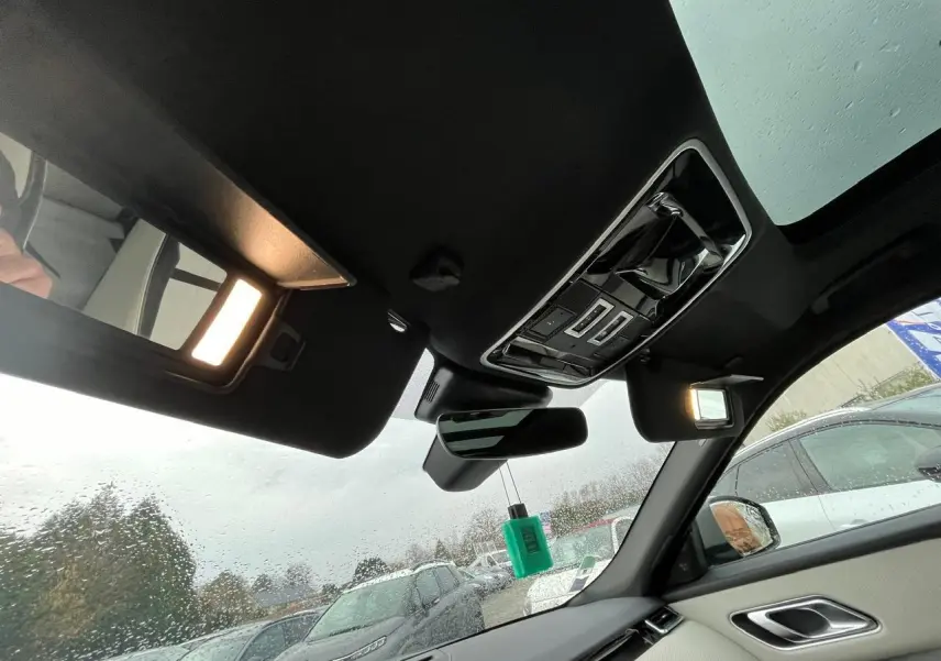 Vue intérieure du Range Rover Velar 2017 côté droit, montrant le toit ouvrant panoramique et les miroirs de courtoisie éclairés.