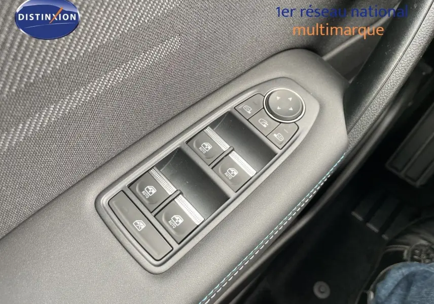 Gros plan sur les commandes de lève-vitres côté conducteur d'une Renault Symbioz gris cassiopée métal, intérieur noir.