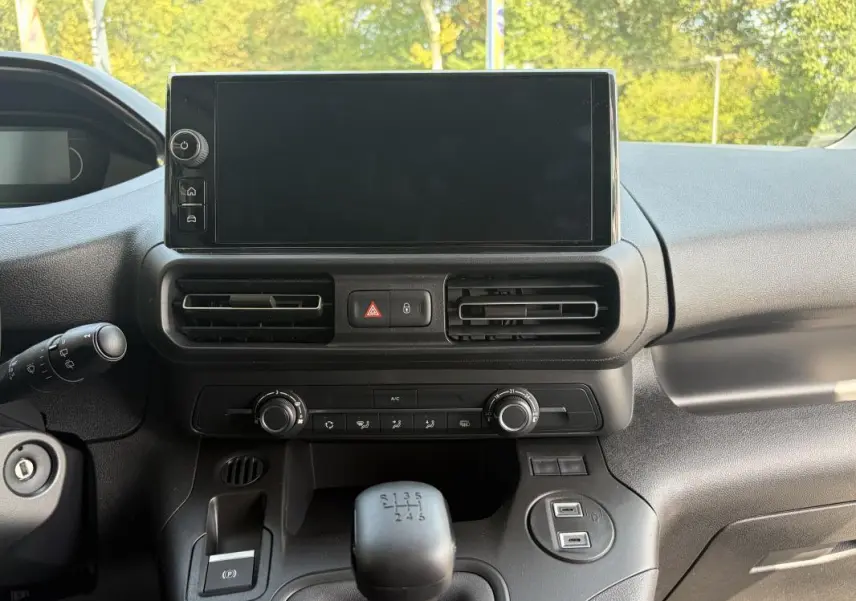 Tableau de bord du Peugeot Partner blanc 2026, vue frontale centrée sur l’écran tactile et la boîte manuelle.