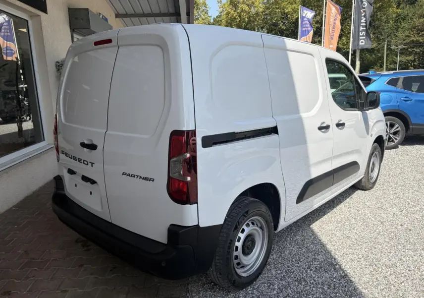 Peugeot Partner blanc en vue 3/4 arrière droit, fourgon utilitaire avec portes arrière battantes et protections latérales noires.