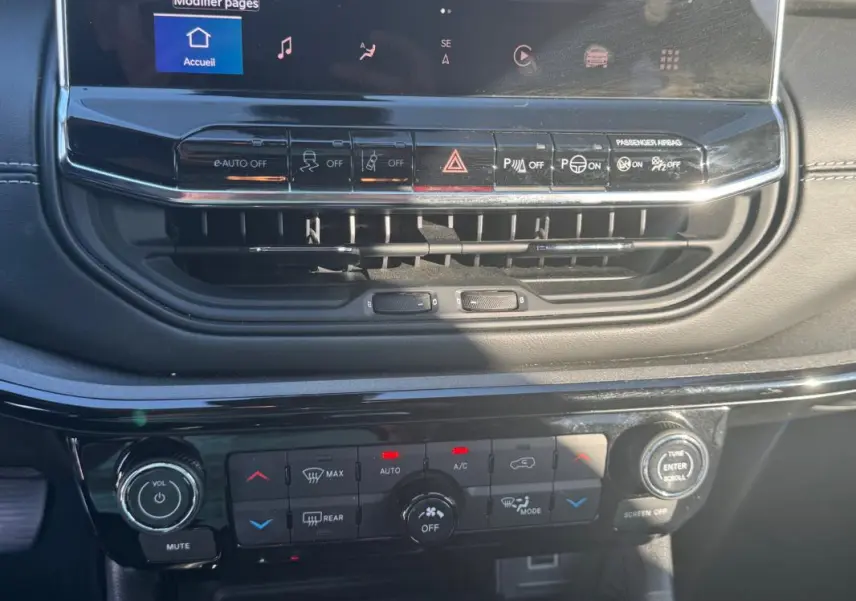 Vue rapprochée du tableau de bord du Jeep Compass 2025, montrant les commandes de climatisation et l'écran tactile.