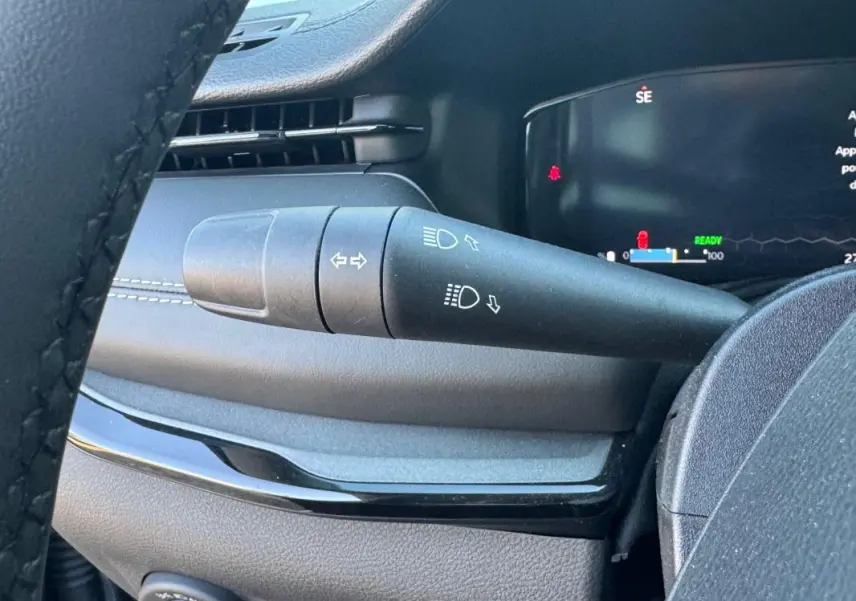 Gros plan sur la manette des clignotants et des feux dans l'habitacle du Jeep Compass bleu 2025.