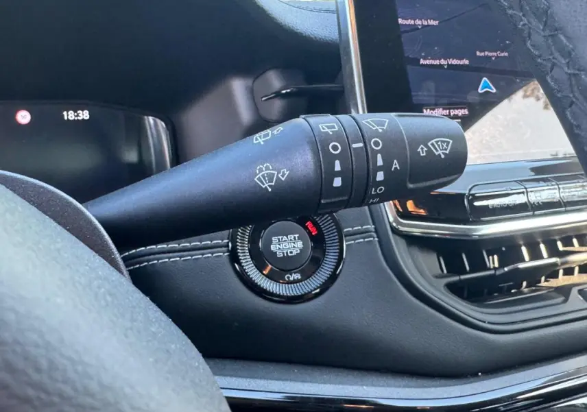 Gros plan sur la commande d’essuie-glace et le bouton start/stop du tableau de bord du Jeep Compass bleu 2025.