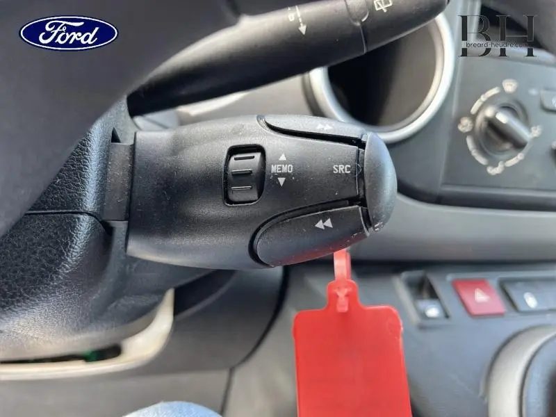 Gros plan sur la commande au volant noire avec fonctions MEMO et SRC dans l'habitacle d'un Citroën Berlingo blanc Banquise 2017.