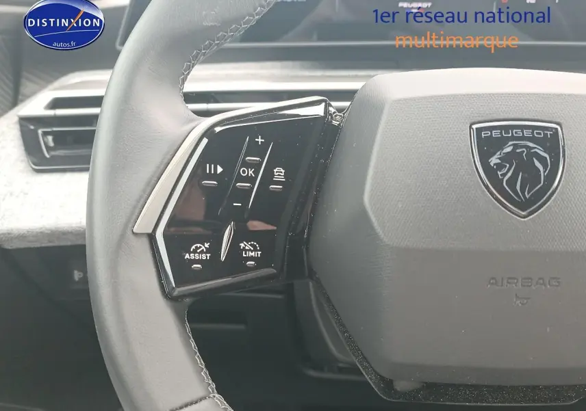 Gros plan sur le volant cuir gris du Peugeot 3008 2025 avec commandes multifonctions et logo lion central.