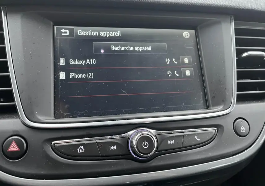 Écran tactile central de l’Opel Crossland X 2021 affichant la gestion des appareils Bluetooth, avec commandes autour en plastique noir.