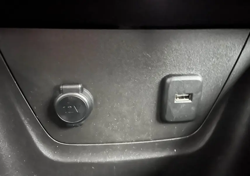 Prise 12V et port USB intégrés dans l’habitacle de l’Opel Crossland X bleu clair, vue rapprochée du tableau de bord.