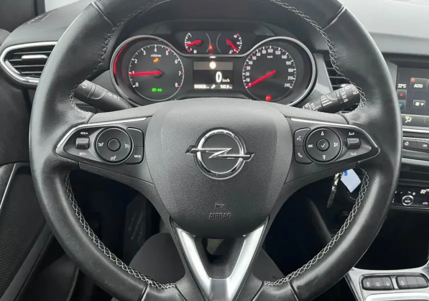 Vue rapprochée du volant en cuir noir de l'Opel Crossland X 2021 avec commandes intégrées et tableau de bord digital.