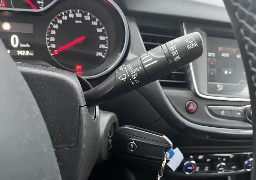 Gros plan sur la commande d'essuie-glace à droite du volant dans l'habitacle noir de l'Opel Crossland X 2021.