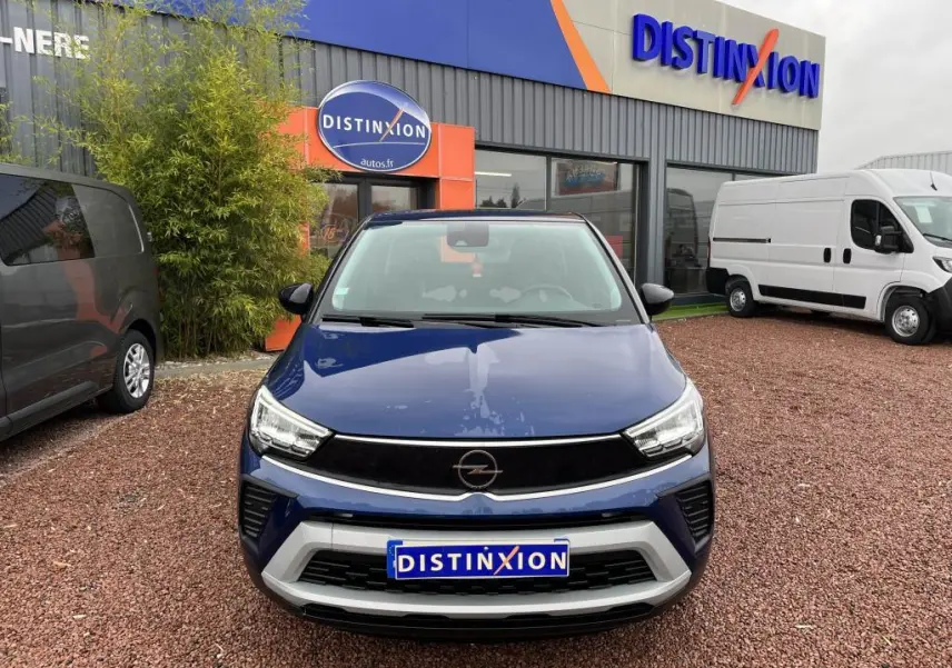 Vue avant d'un Opel Crossland X bleu clair avec toit noir, stationné devant un concessionnaire Distinxion.
