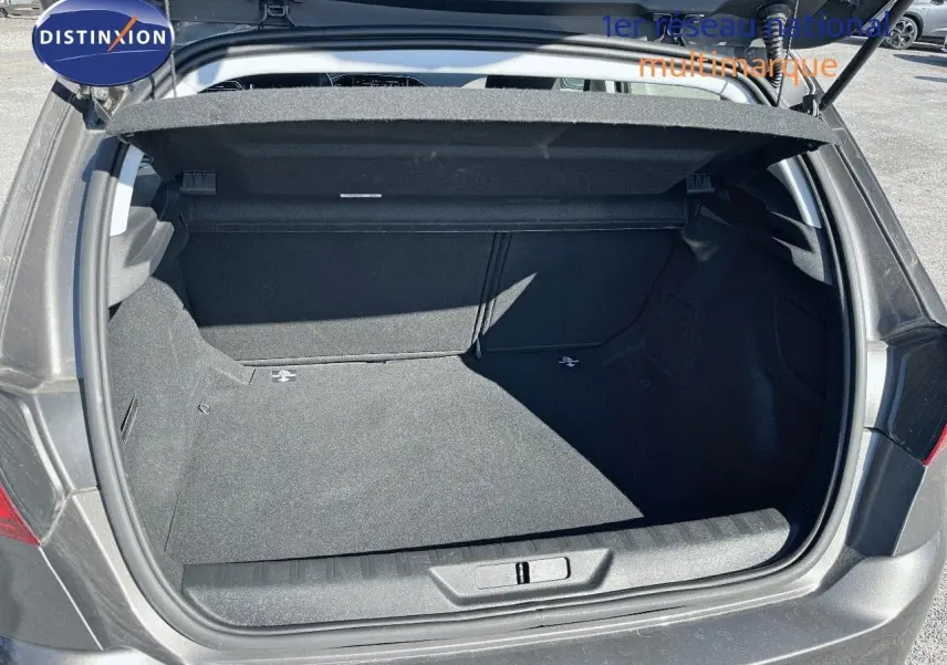 Coffre ouvert vu de l'arrière d'une Peugeot 308 Business gris foncé, montrant un espace de rangement propre et spacieux.