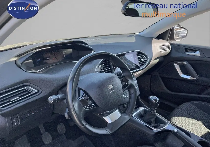 Vue intérieure du poste de conduite de la Peugeot 308 Business 2020, volant et levier de vitesses manuelle visibles.