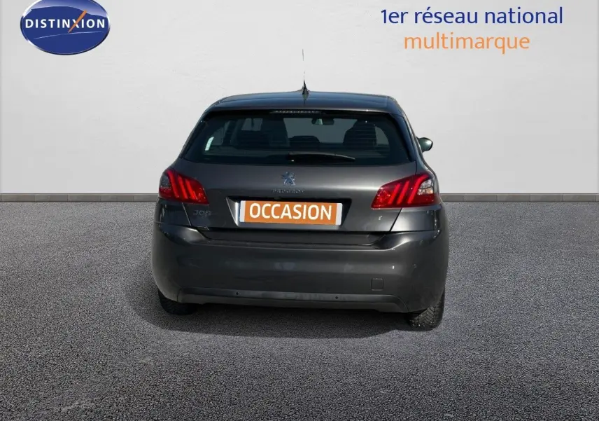 Vue arrière de la Peugeot 308 Business gris foncé de 2020 avec feux arrière allumés et plaque occasion visible.