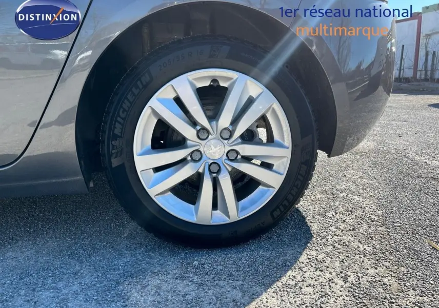 Gros plan sur la roue arrière droite d’une Peugeot 308 Business gris foncé, avec jante alliage et pneu Michelin.