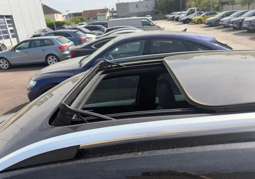 Toit ouvrant panoramique partiellement ouvert sur un SEAT Ateca noir vu de dessus côté gauche.