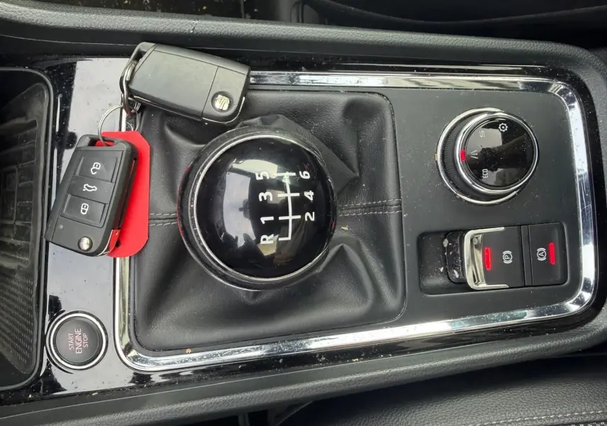 Vue rapprochée de la console centrale noire du SEAT Ateca 2.0 TDI 116 XCELLENCE avec levier de vitesse manuel et clés posées.