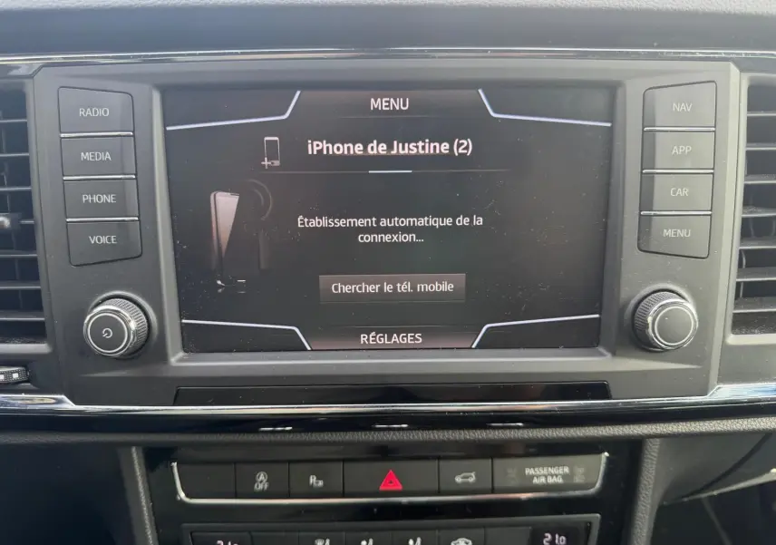 Écran tactile central du tableau de bord du SEAT Ateca noir, affichant la connexion Bluetooth d’un iPhone.