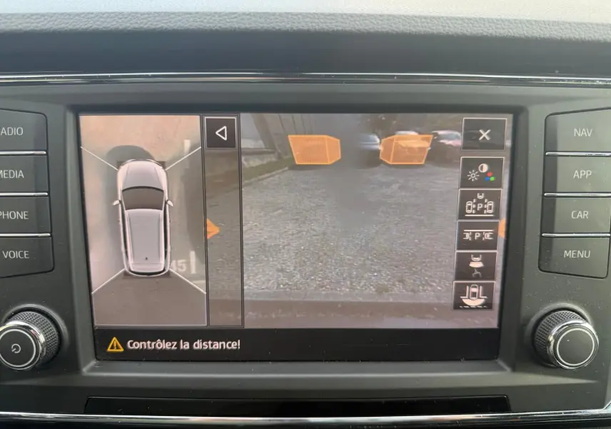 Écran de caméra de recul et vue 360° du SUV SEAT Ateca noir, affichant l'aide au stationnement active.