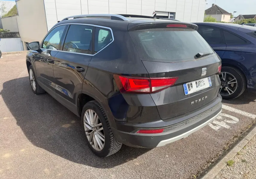 Vue 3/4 arrière droite d'un SEAT Ateca noir avec jantes alliage et feux arrière LED, stationné en extérieur.