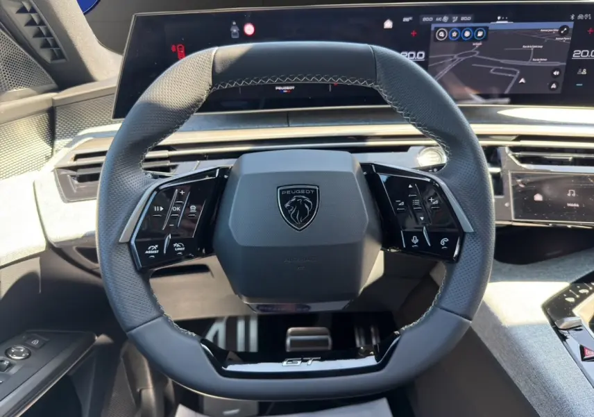 Vue rapprochée du volant cuir noir GT de la Peugeot 5008 2025 avec commandes multifonctions et tableau de bord numérique.