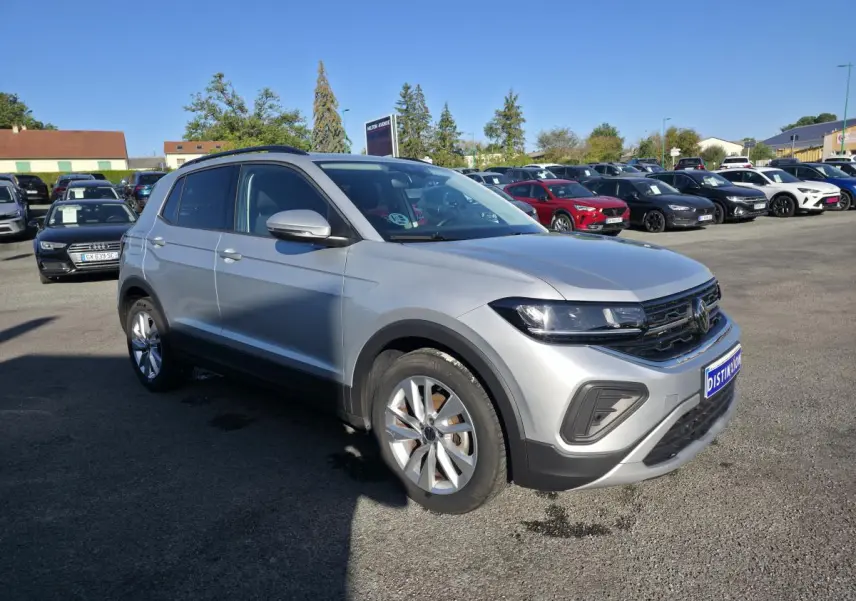 Volkswagen T-Cross gris métallisé en 3/4 avant droit, avec jantes alliage et calandre noire distinctive.