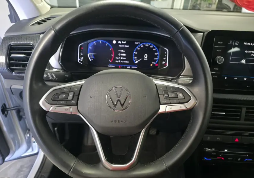 Vue rapprochée du volant en cuir noir et du combiné digital du Volkswagen T-Cross gris 2025, version Life.