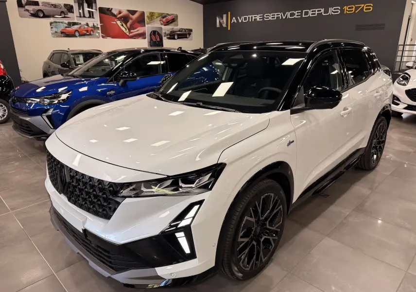 Renault Austral Full hybrid blanc nacré toit noir, vue 3/4 avant droit, avec calandre noire et jantes noires stylisées.