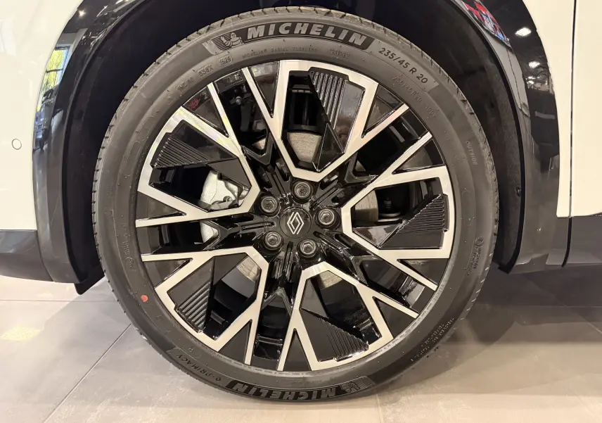 Gros plan sur la jante noire et argentée de 20 pouces avec logo Renault, sur roue Michelin du Renault Austral blanc nacré.