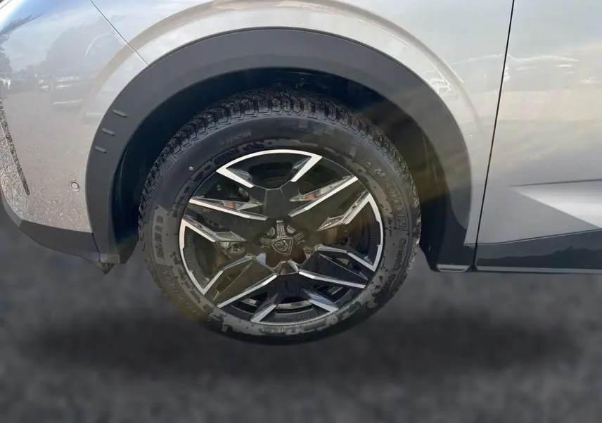 Gros plan sur la roue avant gauche du Peugeot 3008 gris Artense avec jante alu au design moderne.