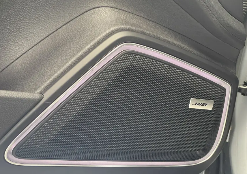 Gros plan sur l'enceinte Bose intégrée dans la porte intérieure noire du Porsche Panamera Sport Turismo gris 2018.