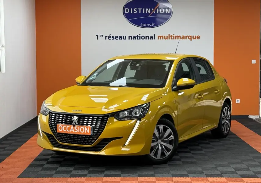 Peugeot 208 jaune clair vue 3/4 avant avec calandre noire et jantes 16 pouces en intérieur showroom.