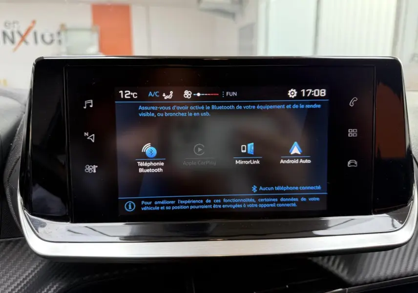 Écran tactile 7 pouces du système multimédia de la Peugeot 208 affichant les options Bluetooth, MirrorLink et Android Auto.